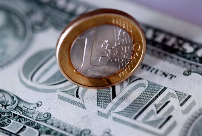Archivo - FILED - 09 May 2011, Cologne: A one-euro coin lies on a one-dollar bill. The value of the euro currency has fallen to reach parity with the US dollar for the first time in almost 20 years. Photo: picture alliance / Oliver Berg/dpa