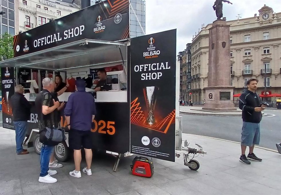 Algunos aficionados comprando recuerdos de la final que se celebrará este miércoles.