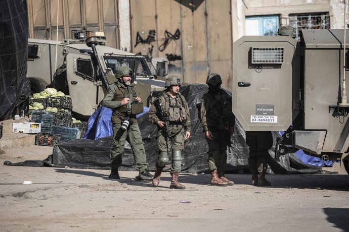 Archivo - Arquivo - 07 de janeiro de 2025, Territórios Palestinos, Jenin: Soldados israelenses caminham perto de um mercado destruído durante uma operação militar israelense no campo de refugiados de Far'a, na cidade de Jenin, no norte da Cisjordânia. Fot