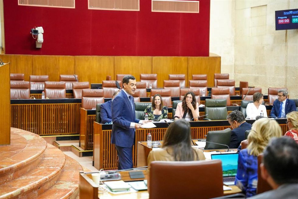El presidente de la Junta de Andalucía, Juanma Moreno, este jueves durante su intervención en el Pleno del Parlamento mientras al fondo se ven los escaños vacíos del Grupo Socialista. 
