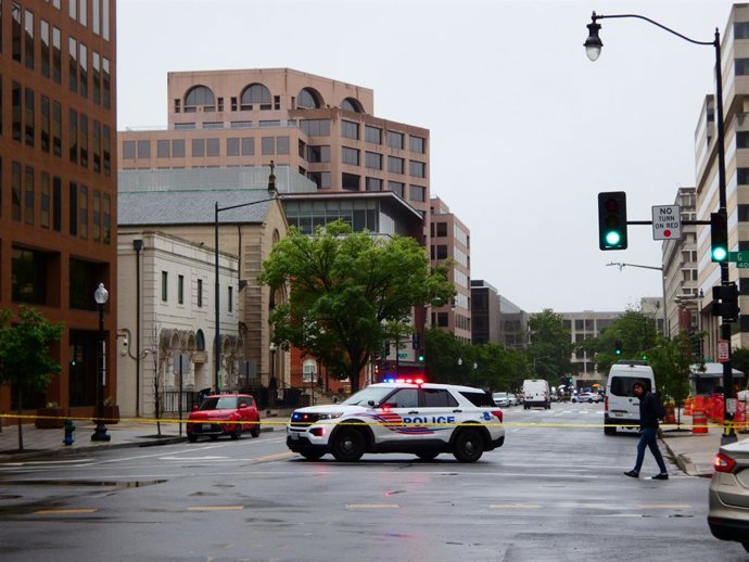 22 de maio de 2025, EUA, Washington: Um carro de polícia está parado na cena do crime isolada no centro da cidade de Washington. Dois funcionários da embaixada israelense foram baleados em frente ao Museu Judaico da Capital. Foto: Luzia Geier/dpa