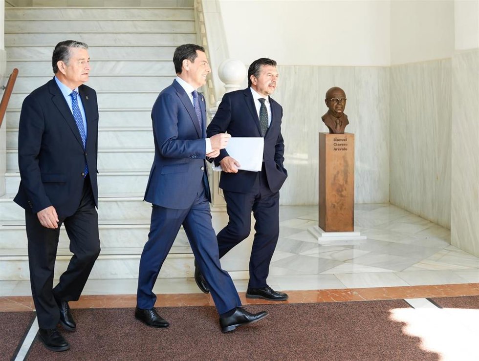 El consejero de la Presidencia, Antonio Sanz; el presidente de la Junta de Andalucía, Juanma Moreno, y el portavoz del Grupo Parlamentario Popular, Toni Martín, este jueves en los pasillos del Parlamento.