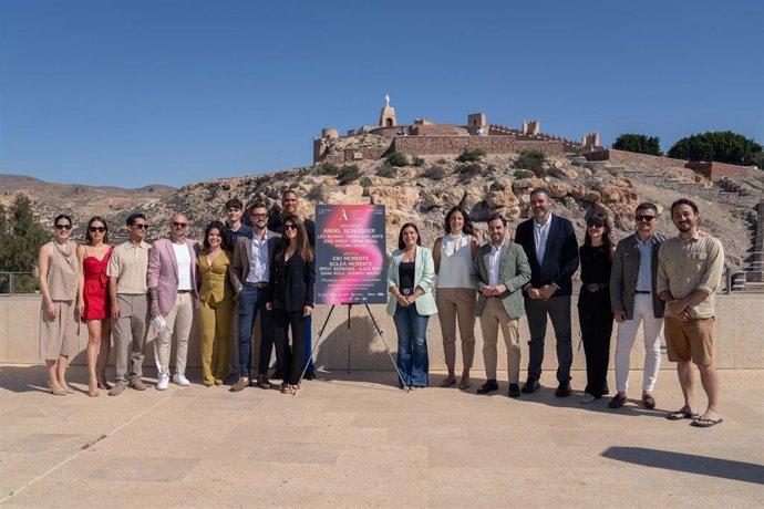 Representantes institucionales, diseñadores y artistas participantes posan tras la presentación de AMAC 2025, celebrada en la terraza del Centro de Interpretación Patrimonial, con la Alcazaba de Almería al fondo.
