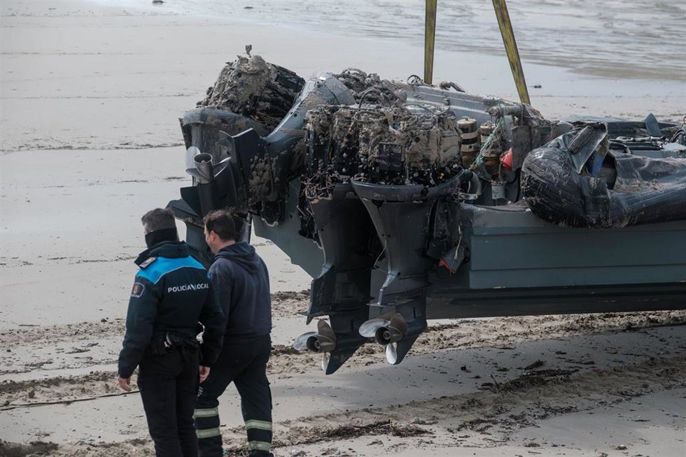Archivo - Un policía junto a la planeadora varada en la playa de Nemiña, en Muxía. Archivo.