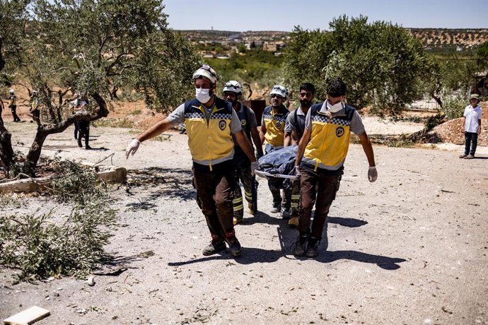 Archivo - Arquivo - 05 de agosto de 2023, Síria, Idlib: Membros da Defesa Civil da Síria, também conhecidos como Capacetes Brancos, recuperam o corpo de uma vítima morta em ataques aéreos russos nos arredores de Idlib. Como resultado do ataque, três civis