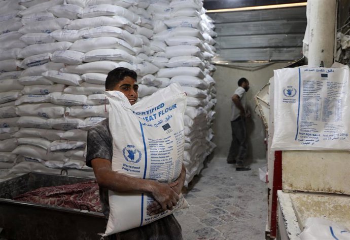 Unos trabajadores empaquetan pan para su distribución en la panadería del Programa Mundial de Alimentos (PMA) en Deir al Balá, centro de la Franja de Gaza