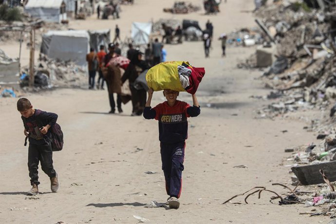 22 de maio de 2025, Cidade de Gaza, Faixa de Gaza, Território Palestino: Moradores palestinos fugindo para áreas que acreditam ser mais seguras, carregando seus pertences, após fortes ataques israelenses em Jabalia, no norte de Gaza, em 22 de maio de 2025