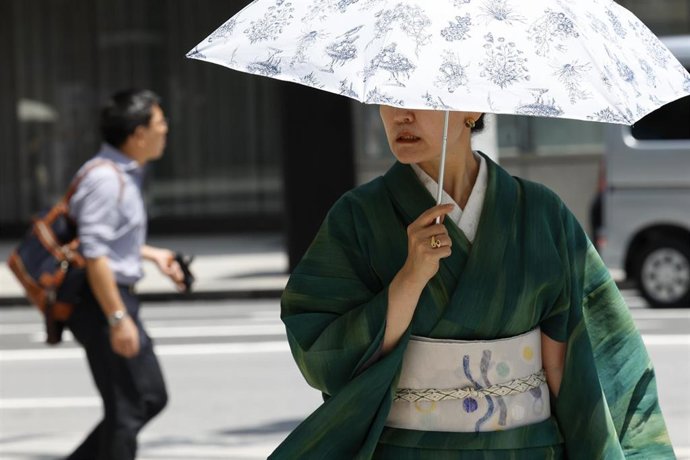 Archivo - 26 July 2024, Japan, Tokyo: A woman wearing traditional Japanese kimono shades herself with an umbrella from the heat in the Ginza shopping district. Photo: Rodrigo Reyes Marin/ZUMA Press Wire/dpa