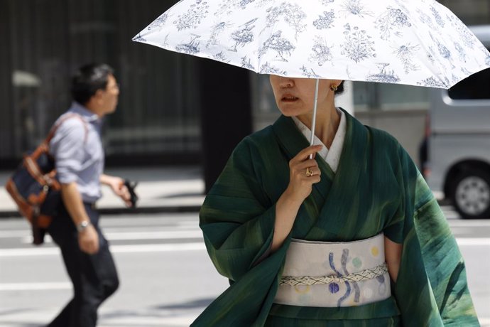 Archivo - 26 July 2024, Japan, Tokyo: A woman wearing traditional Japanese kimono shades herself with an umbrella from the heat in the Ginza shopping district. Photo: Rodrigo Reyes Marin/ZUMA Press Wire/dpa