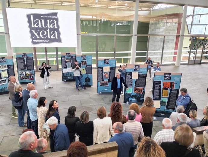 El comisario de la exposición 'Lauaxeta, arquitecto de sueños', Jon Kortazar (centro), explica frente al público los contenidos de la muestra en el fronton de Laukiz.