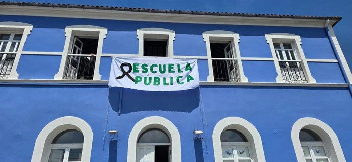 Sede deun Colegio Rural Asturiano con una pancarta en defensa de la escuela pública.