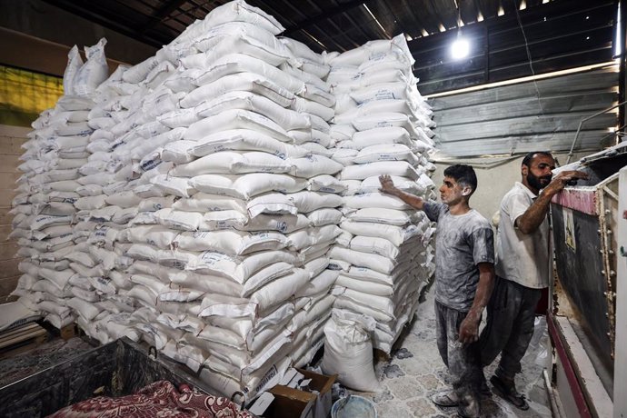 22 May 2025, Palestinian Territories, Deir al Balah: Workers package bread for distribution at the World Food Programme (WFP) bakery after a limited amount of flour entered the Gaza Strip, where border crossings have remained closed since March 2 due to I