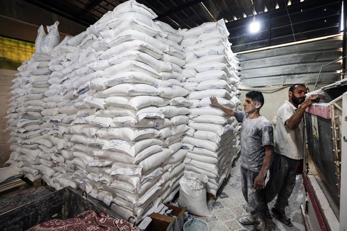 22 de maio de 2025, Territórios Palestinos, Deir al Balah: Trabalhadores empacotam pão para distribuição na padaria do Programa Mundial de Alimentos (PMA) depois que uma quantidade limitada de farinha entrou na Faixa de Gaza, onde as passagens de fronteir