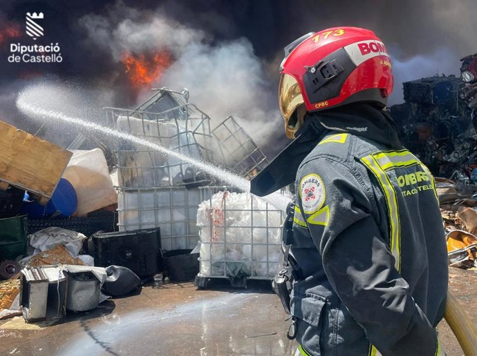 Els bombers treballen en l'extinció d'un incendi en una empresa de reciclatge a Borriana