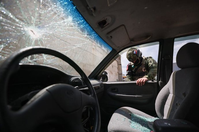 Imagem de arquivo de um oficial da Polícia Militar Russa em frente aos danos causados por um ataque de drone.