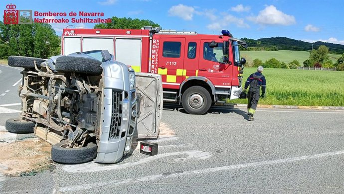 Los bomberos junto a uno de los vehículos accidentados.