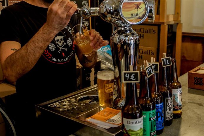 Archivo - Un camarero tira una cerveza artesanal en uno de los bares que participan en ‘Artesana Week Lavapiés’, en la calle Argumosa, a  2 de abril de 2022, en Madrid (España). En la VII edición de la feria de la cerveza artesana, de este barrio del cent