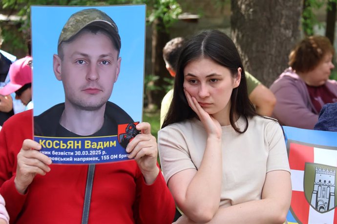 KIEV, May 24, 2025  -- A Ukrainian holds a photo of a missing soldier for help, May 23, 2025. Ukrainian President Volodymyr Zelensky on Friday announced that 390 Ukrainians returned home from captivity during the first stage of prisoner exchange with Russ