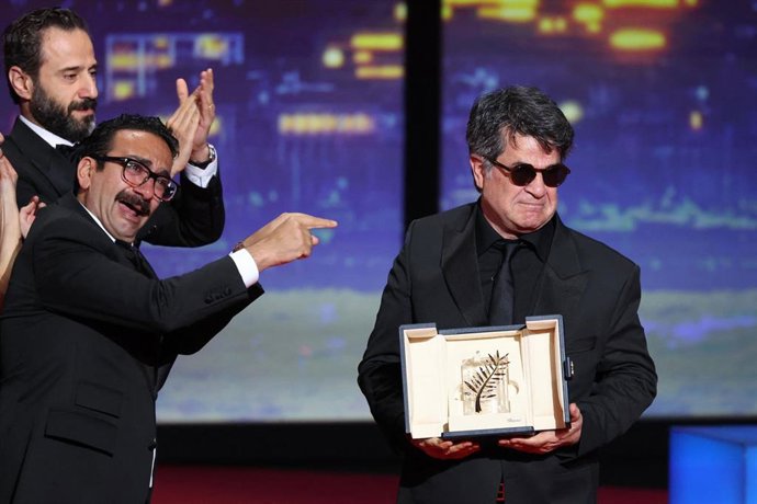 El director, guionista y productor iraní Jafar Panahi (dcha.) y su equipo celebran sobre el escenario tras ganar la Palma de Oro por la película Un simple accidente.         