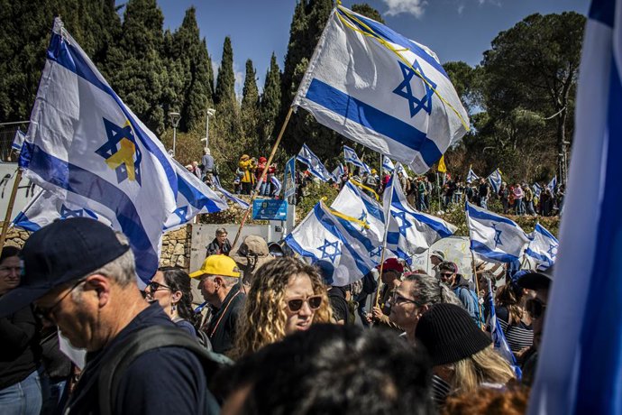 Archivo - Arquivo - 23 de março de 2025, Jerusalém, Israel: Manifestantes israelenses agitam sua bandeira nacional durante uma manifestação em Jerusalém. Milhares de manifestantes se reuniram do lado de fora do escritório da PM na manhã de domingo, quando