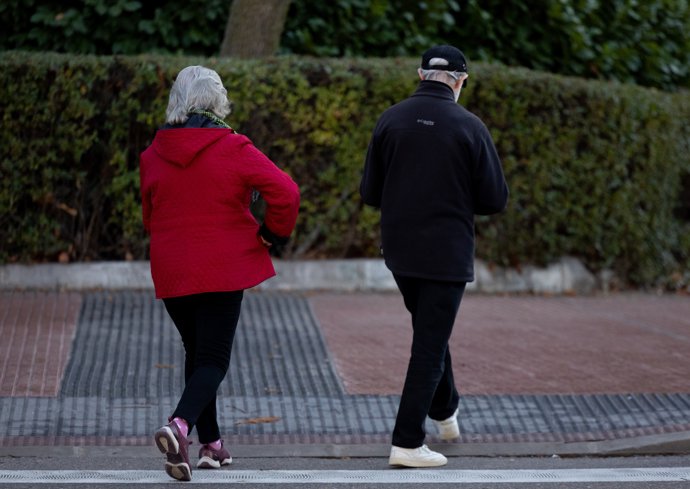 Dos personas caminan por la calle.