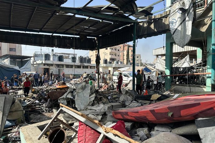 Un grupo de civiles evalua los daños provocados en una escuela con desplazados en la Franja de Gaza