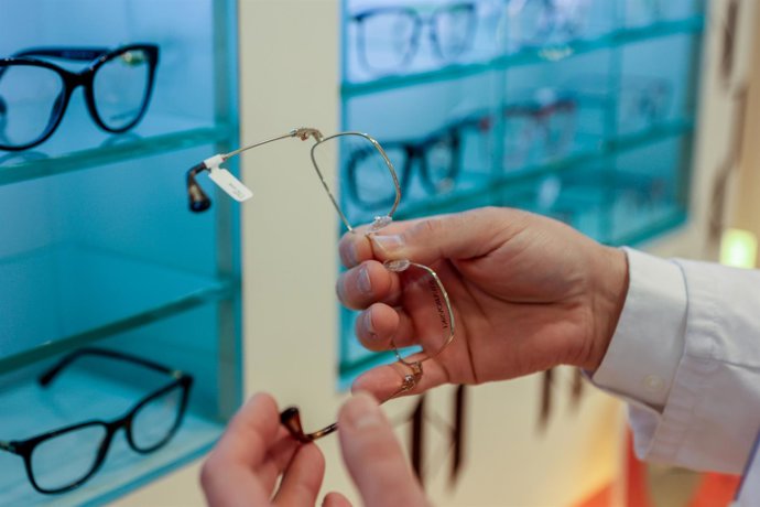 Archivo - Un trabajador de la óptica de Primera Opticos Fersan coloca unas gafas en un expositor, a 30 de mayo de 2024, en Alcalá de Henares, Madrid (España). 