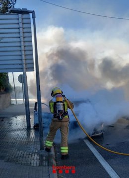 Els Bombers de la Generalitat extingint el cotxe incendiat