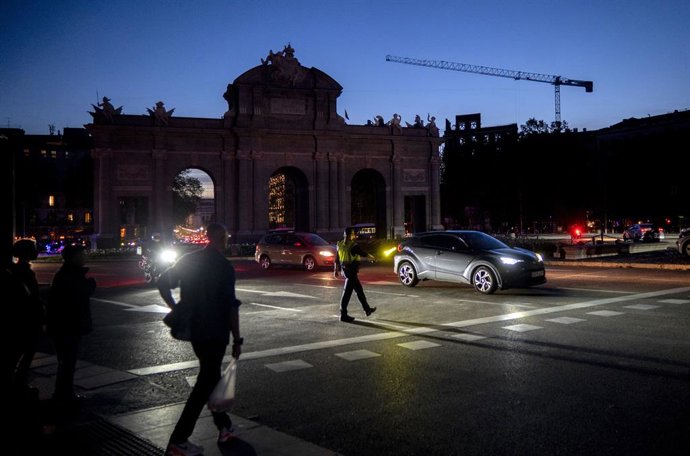 Uma mulher com uma lanterna na Puerta de Alcalá após o apagão de eletricidade, em 28 de abril de 2025, em Madri (Espanha).