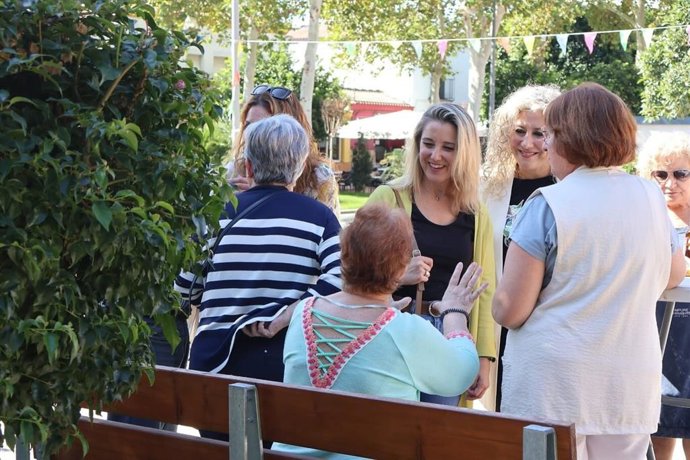 La alcaldesa y la delegada saludan a personas mayores.