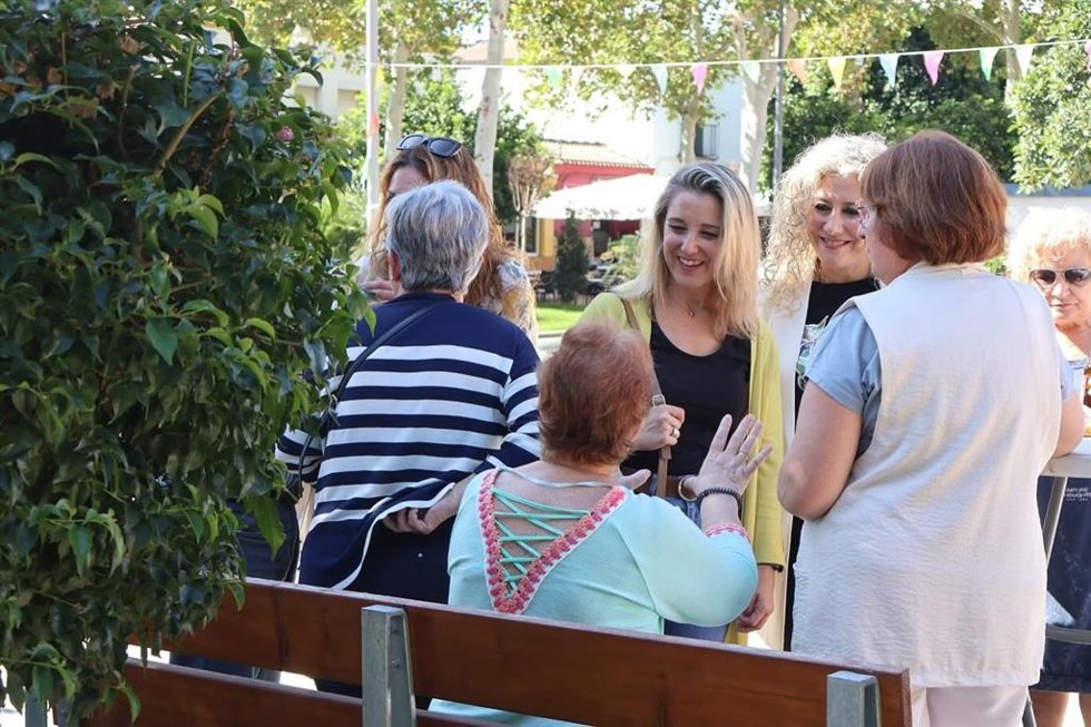 La alcaldesa y la delegada saludan a personas mayores.