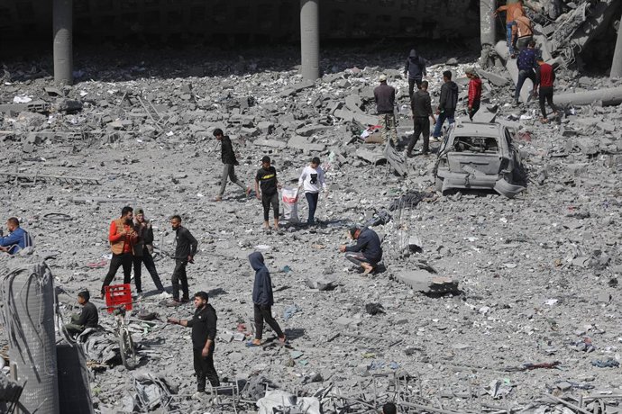 Archivo - Palestinos intenten recuperar les sos pertenencies tres un bombardéu d'Israel contra una escuela qu'acoyía a movíos nel este de la ciudá de Gaza, nel norte de la Franxa de Gaza (arquivu)