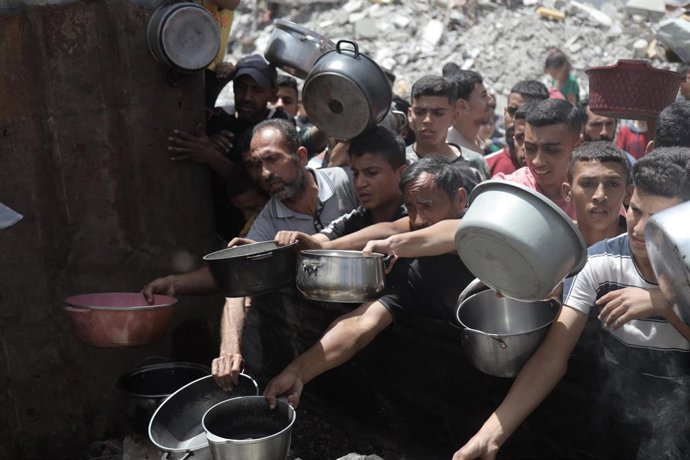 Palestinos esperan recibir comida en un centro de distribución en Yabalia, en el norte de la Franja de Gaza 