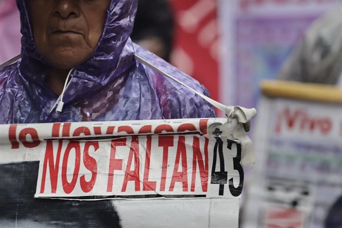 Un hombre sostiene una pancarta en la marcha por los 43 desaparecidos de Ayotzinapa, México.