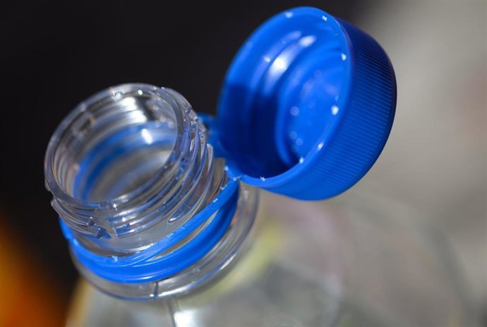 Archivo -  A plastic water bottle with an open cap stands on a table. Foto de archivo.