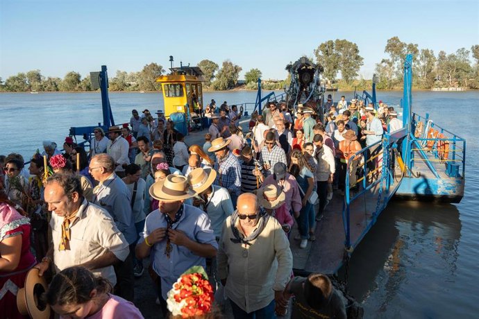 Archivo - La hermandad rociera de Carmona desembarca de la barcaza de Coria del Río en la Romería del pasado año.