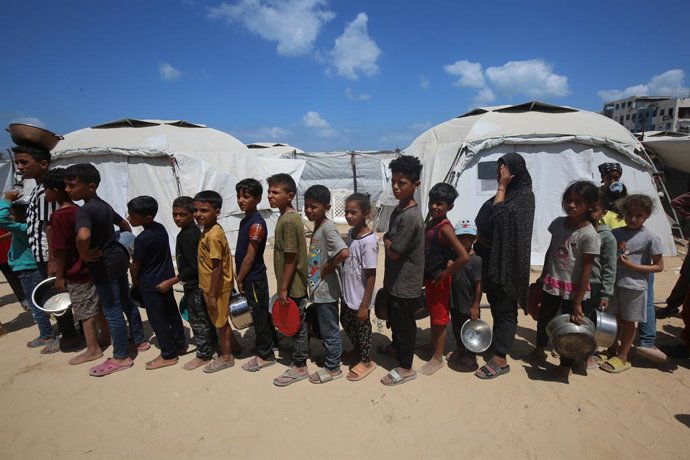 28 de maio de 2025, Territórios Palestinos, Gaza: Organizações beneficentes distribuem refeições quentes aos palestinos na Cidade de Gaza, que estão passando fome devido aos ataques de Israel a Gaza e ao fechamento das fronteiras. Como os ataques implacáv