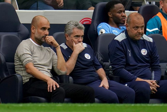 Archivo - 15 August 2021, United Kingdom, London: Manchester City manager Pep Guardiola (L) with assistants Juanma Lillo (C) and Rodolfo Borrell sit on the bench during the English Premier League soccer match between Tottenham Hotspur and Manchester City 