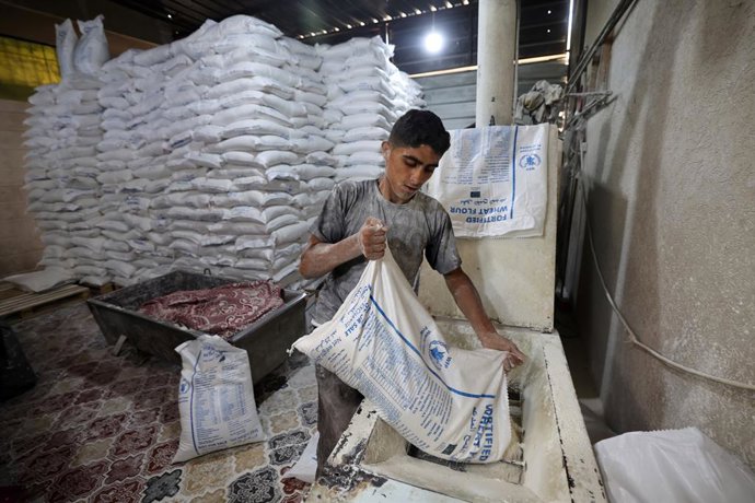 22 de maio de 2025, Deir Al-Balah, Faixa de Gaza, Território Palestino: Trabalhadores embalam pão para distribuição na padaria do Programa Mundial de Alimentos (PMA) depois que uma quantidade limitada de farinha entrou na Faixa de Gaza, onde as passagens 