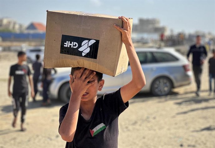 Un niño palestino con una caja de ayuda humanitaria de GHF en Rafá