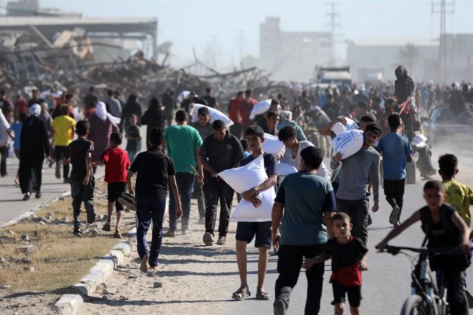 May 28, 2025, Deir El-Balah, Gaza Strip, Palestinian Territory: Displaced Palestinians ferry bags of food aid after people stormed a World Food Programme warehouse in Deir el-Balah in the central Gaza Strip on May 28, 2025. The United Nations on May 28 co