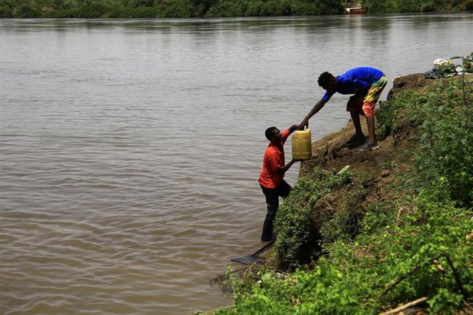 Ciudadanos sudaneses recogen agua del río Nilo en Omdurman, al sur de Jartum, ante la crisis de agua potable que atraviesa la región
