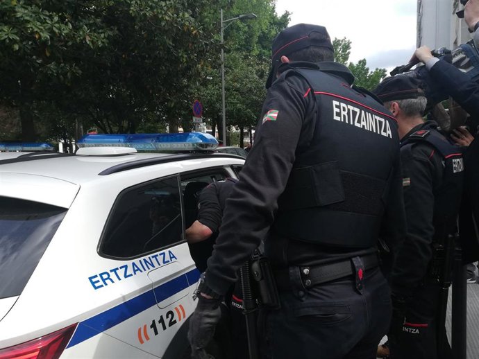 Archivo - Dos ertzainas ante un coche policial