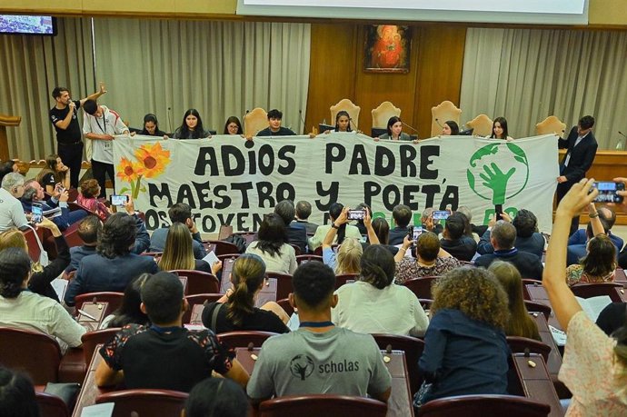Jóvenes sujetan una pancarta en la que se puede leer 'Adiós padre, maestro y poeta'.