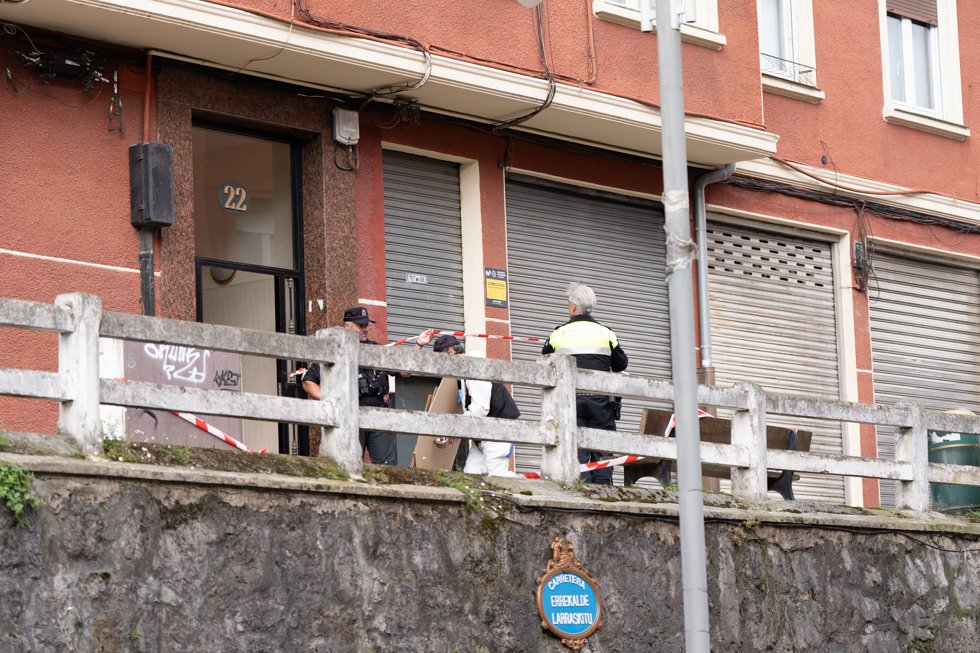 Agentes de policía en la entrada del bloque de viviendas donde un hombre de 43 años que supuestamente ha matado a su hija de 13 años, en Bilbao (Bizkaia)