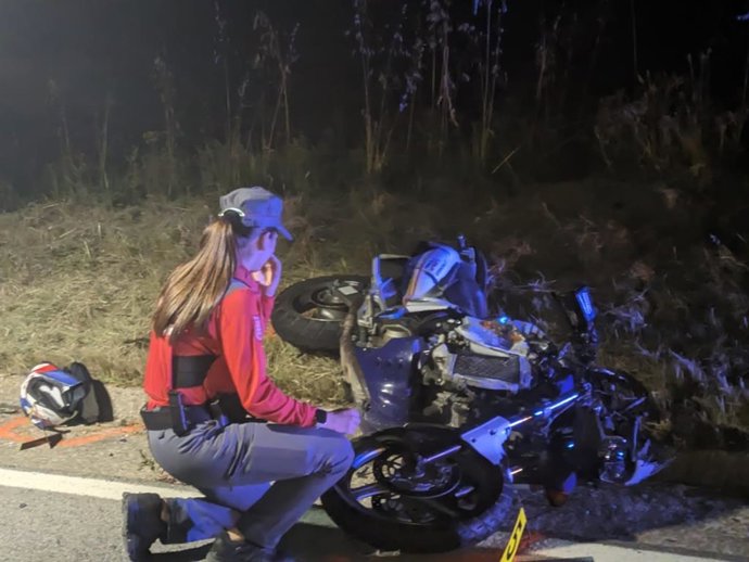 Una agente de la Policía Foral junto a la moto siniestrada.