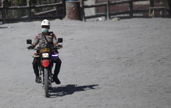 27 July 2019, Indonesia, Subang: Indonesian police officer patrols on a motorcycle at Jayagiri village after Tangkuban Parahu volcano eruption. Photo: Ojan Fauzan/Sijori Images via ZUMA Wire/dpa