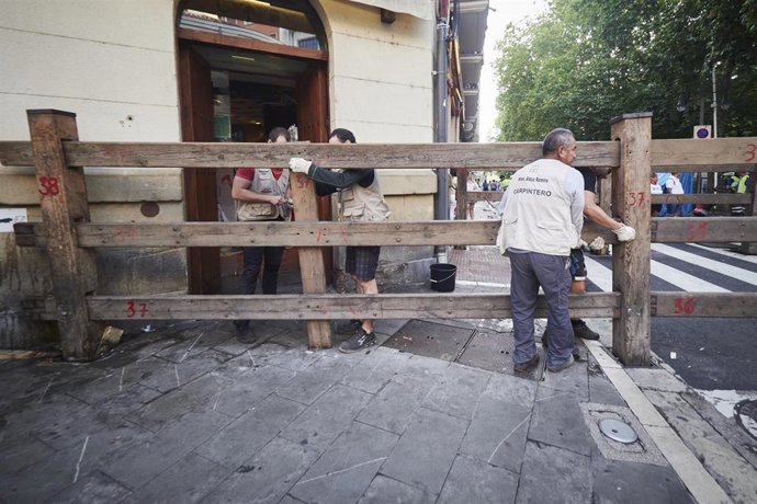 Archivo - Carpinteros recogen el vallado tras el último encierro de las fiestas de San Fermín 2022