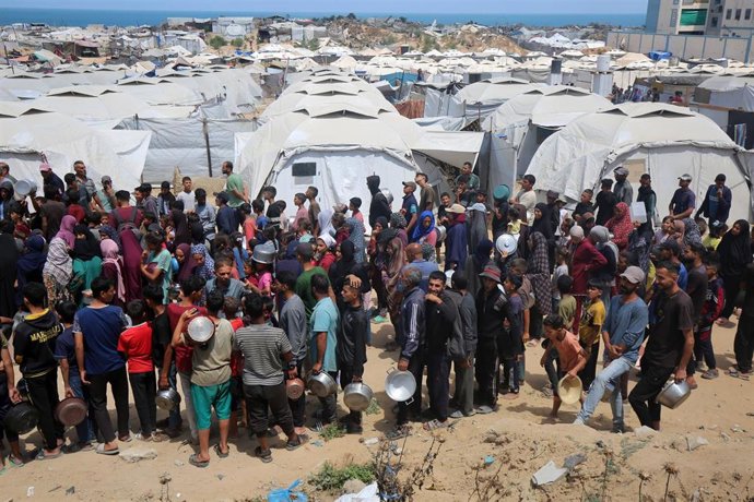 Palestinos intentan obtener alimentos repartidos por una organización caritativa en la ciudad de Gaza, situada en el norte de la Franja de Gaza (archivo)