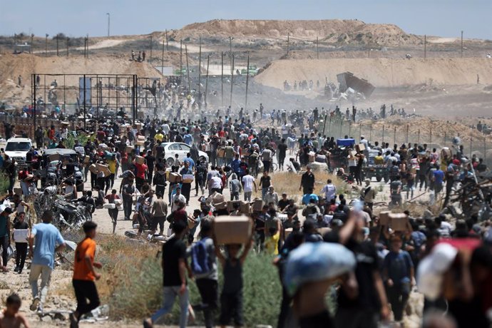 29 May 2025, Palestinian Territories, Bureij: Palestinians walk with aid supplies which they received from the US-backed Gaza Humanitarian Foundation, in Al-Bureij. Photo: Moiz Salhi/APA Images via ZUMA Press Wire/dpa